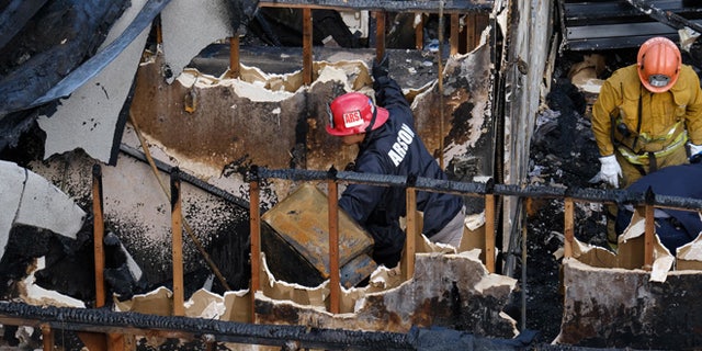 Los Angeles Fire Department arson investigators examine the burned-out ruins of an abandoned office building in the Westlake district just west of downtown Los Angeles Tuesday, June 14, 2016. Two men and two women were found Tuesday after a search using cadaver dogs, bringing the death toll to five. One person was found dead when the building burned Monday evening, June 13. Authorities believe the fire was intentionally set. (AP Photo/Richard Vogel)