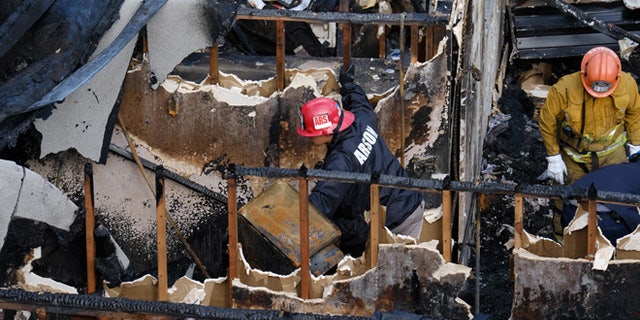 Los Angeles Fire Department arson investigators examine the burned-out ruins of an abandoned office building in the Westlake district just west of downtown Los Angeles Tuesday, June 14, 2016. Two men and two women were found Tuesday after a search using cadaver dogs, bringing the death toll to five. One person was found dead when the building burned Monday evening, June 13. Authorities believe the fire was intentionally set. (AP Photo/Richard Vogel)
