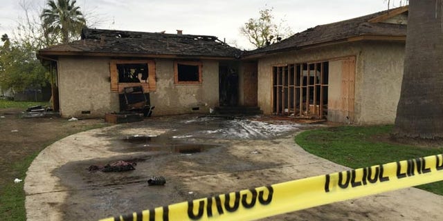 An abandoned house where multiple people died early Sunday, Dec. 13, 2015 in Fresno, Calif., is seen after flames were extinguished. The Fresno Fire Department says fire crews brought several people out of the boarded-up home. (Paul Schlesinger/The Fresno Bee via AP) LOCAL PRINT OUT (VISALIA TIMES-DELTA, REEDY EXPONENT, KINGBURG RECORDER, SELMA ENTERPRISE, HANFORD SENTINEL, PORTERVILLE RECORDER, MADERA TRIBUNE, THE BUSINESS JOURNAL FRENSO); LOCAL STATIONS OUT (KSEE24, KFSN30, KGE47, KMPH26)