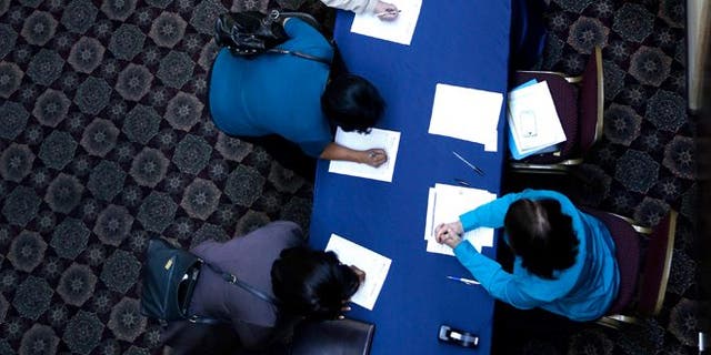 In this Wednesday, Jan. 22, 2014, photo, job seekers line up to sign in before meeting prospective employers at a career fair at a hotel in Dallas. The Labor Department releases employment data for February, on Friday, March, 7, 2014. (AP Photo/LM Otero)