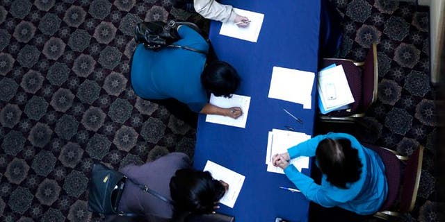 In this Wednesday, Jan. 22, 2014, photo, job seekers line up to sign in before meeting prospective employers at a career fair at a hotel in Dallas. The Labor Department releases employment data for February, on Friday, March, 7, 2014. (AP Photo/LM Otero)