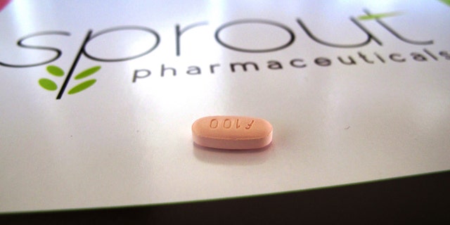 FILE - In this Friday, Sept. 27, 2013, file photo, a tablet of flibanserin sits on a brochure for Sprout Pharmaceuticals in the company's Raleigh, N.C., headquarters. (AP Photo/Allen G. Breed, File)
