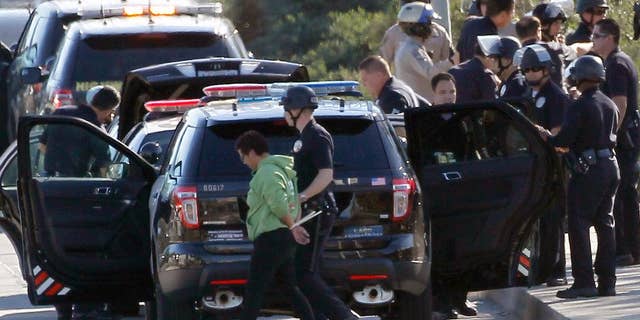 Nov. 26, 2014: A protestor is handcuffed and taken away by a police officer after the arrest of a small group of protesters who sat down in a bus lane alongside the U.S. 101.