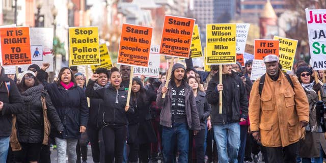 Some of the several hundred demonstrators marching down M Street in Georgetown Saturday afternoon towards the key bridge. The protest focused on Michael Brown's death and the recent grand jury decision in Ferguson. during a Ferguson Protest in Georgetown, DC, Saturday, Nov. 29, 2014. (AP Photo/Erin Schaff)