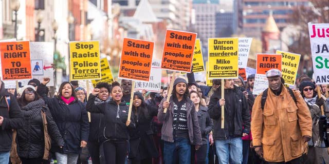 Some of the several hundred demonstrators marching down M Street in Georgetown Saturday afternoon towards the key bridge. The protest focused on Michael Brown's death and the recent grand jury decision in Ferguson. during a Ferguson Protest in Georgetown, DC, Saturday, Nov. 29, 2014. (AP Photo/Erin Schaff)