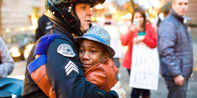 Nov. 25: Portland police Sgt. Bret Barnum, left, and Devonte Hart, 12, hug at a rally in Portland, Ore., where people had gathered in support of the protests in Ferguson, Mo.