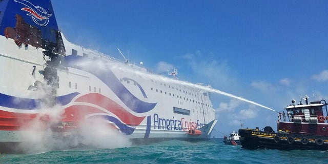 En esta imagen, proporcionada por la Guardia Costera de Estados Unidos, una embarcación de los bomberos de San Juan, en Puerto Rico, usa una manguera para enfrÃar el casco del crucero Caribbean Fantasy, que se incendió a una milla del muelle de San Juan, en Puerto Rico, el 17 de agosto de 2016. (Jonathan Lally/US Coast Guard via AP)