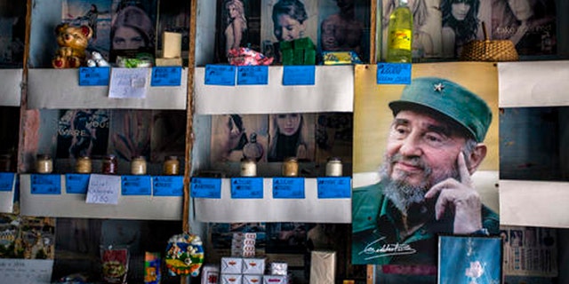 In this July 23, 2016 photo, a picture of Cuban Revolution leader Fidel Castro is placed on the shelves of a state rationing store or "bodega," ahead of his upcoming 90th birthday in Havana, Cuba. During 47 years in power, Fidel was a constant presence for Cubans but prohibited the statues, portraits and other tributes beloved by other total leaders. (AP Photo/Desmond Boylan)