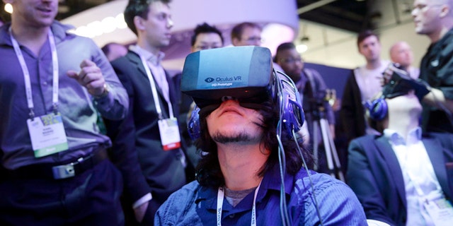 Attendees play a video game wearing Oculus Rift virtual reality headsets at the Intel booth at the International Consumer Electronics Show (CES), in Las Vegas.
