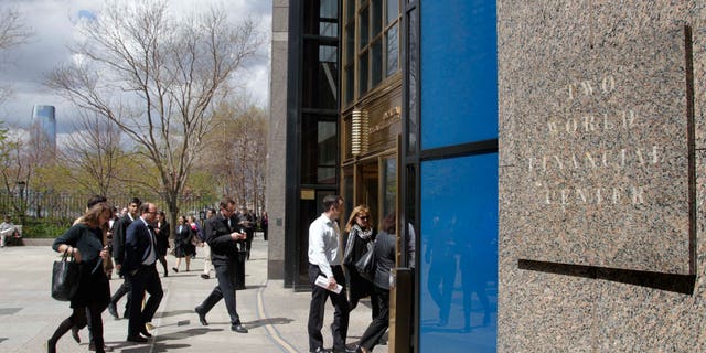 Office workers return to Two World Financial Center after it was briefly evacuated in New York, Thursday, April 12, 2012. Authorities say an evacuation was ordered as a precaution at a World Financial Center building after a security guard reported a package that seemed suspicious. (AP Photo/Seth Wenig)