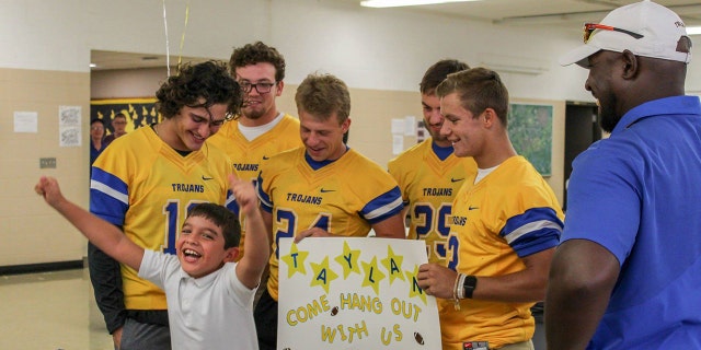 Taylan celebrates after Findlay High School football players invited him to join them on the sidelines this season.