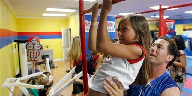Action Fitness owner Steve Ewing, right, trains Kaela Ewing, 8, at the gym in Placentia, Calif., Tuesday, Aug. 12, 2008.