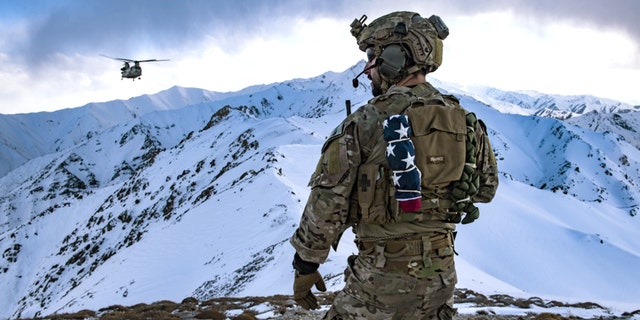 A long way from the beach or a July 4th barbecue a U.S. Air Force pararescueman, assigned to the 83rd Expeditionary Rescue Squadron, communicates with a U.S. Army Task Force Brawler CH-47F Chinook during a training exercise at an undisclosed location in the the mountains of Afghanistan, March 14, 2018.
