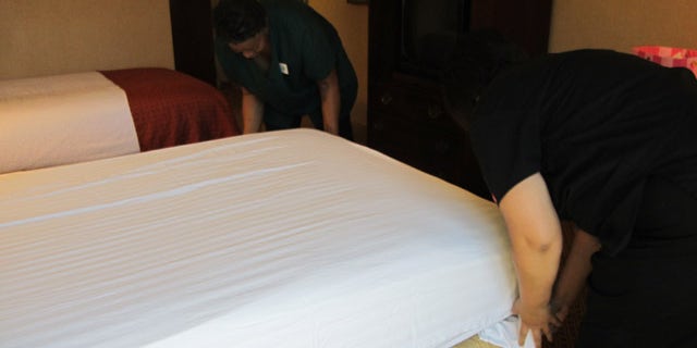 Housekeepers make a bed at the Holiday Inn Fresno Airport.