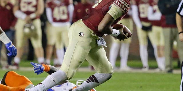 Florida State quarterback Jameis Winston scrambles out of the pocket as he is pressured by Florida defensive back Brian Poole during the second half of an NCAA college football game in Tallahassee, Fla., Saturday, Nov. 29, 2014. Florida State won 24-19. (AP Photo/John Raoux)
