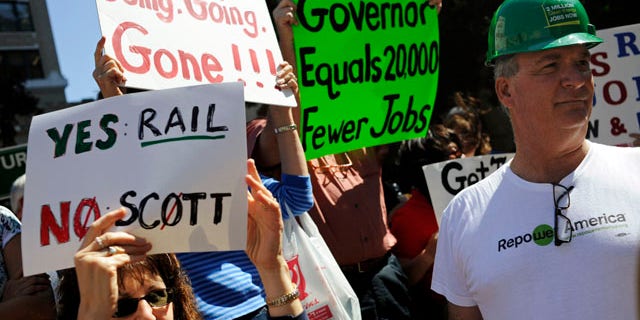 Feb. 21: Erik Arens, right, stands beside Farah Stokes as they participate in a rally to support a high-speed rail at City Hall Plaza in downtown Tampa, Fla. Gov. Rick Scott rejected $2.4 billion in federal funding for the bullet train project.