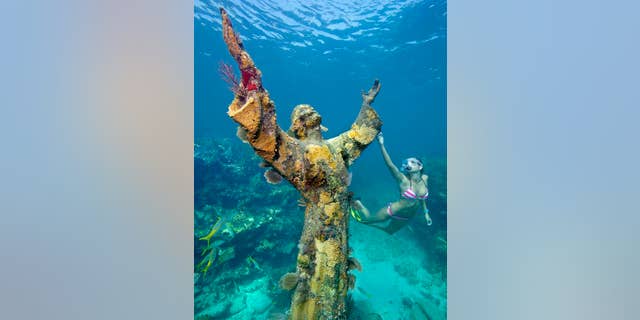 Katherine Wieland snorkels by the the "Christ of the Abyss" statue, an underwater icon for John Pennekamp Coral Reef State park, off Key Largo, Fla. Named after a former Miami newspaper editor, Pennekamp is the nation's first underwater preserve. FOR EDITORIAL USE ONLY (Stephen Frink/Florida Keys News Bureau)
