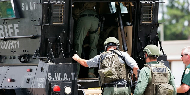 Bay County Sheriff's Office deputies enter an armored vehicle at the corner of 23rd Street and Beck Avenue, Tuesday, May 22, 2018, in Panama City, Fla., in response to an active shooter in the area.