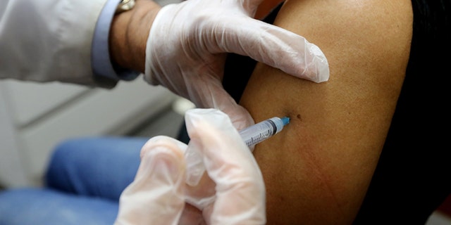 NEW YORK, NY - JANUARY 14: Phamacist Prakash Deshpande injects a patient with influenza vaccine at a Manhattan pharmacy on January 14, 2013 in New York City. The state of New York has declared a public health emergency in a flu epidemic of more than 19,000 confirmed cases in the state. (Photo by Mario Tama/Getty Images)
