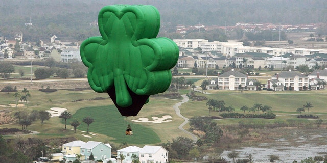 A green shamrock hot-air balloon, named "Paddy" and flown by Orlando Balloon Rides, drifts over Florida on St. Patrick's Day.