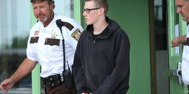 In this photo taken June 30, 2014, John LaDue, accused of planning an attack on his school, is escorted by Waseca County Sheriff's Deputies for a hearing in Waseca, Minn. District Judge Robert Birnbaum on Friday, Aug. 21, 2015, has certified the Waseca teenager, accused of planning to kill his family and attack his high school, to stand trial as an adult. (Elizabeth Flores/Star Tribune via AP) MANDATORY CREDIT; ST. PAUL PIONEER PRESS OUT; MAGS OUT; TWIN CITIES LOCAL TELEVISION OUT