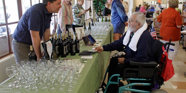 In this photo taken Sunday, April, 17, 2011, Andy Demsky, left, of Shafer Vineyards, talks with a veteran about the 2008 Merlot he was pouring during a lunch at the Veterans Home of California in Yountville, Calif. The lunch included a program called Vintners for Veterans which provides high-quality wines to the men and women at the home to be enjoyed with their Sunday meal. (AP Photo/Eric Risberg)