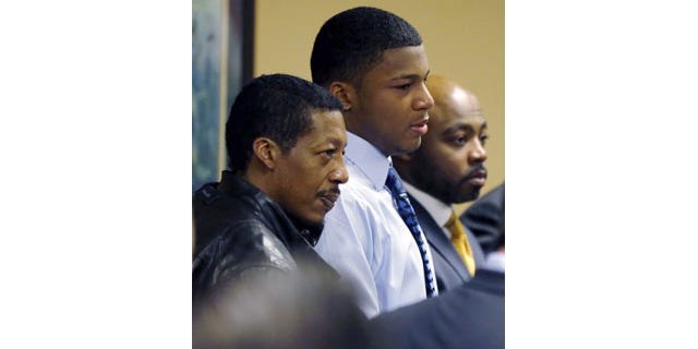 Ma'lik Richmond, center, stands with his father, Nathaniel Richmond, left, and attorney Walter Madison in Steubenville, Ohio, March 17, 2013.