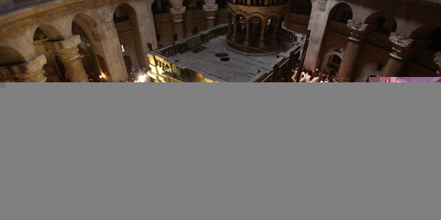 Roman Catholic clergy men hold candles as they circle the aedicule during the Holy Thursday Easter procession at the Church of the Holy Sepulchre in Jerusalem's Old City on April 09, 2009. Christian believers around the world mark the solemn period of Easter in celebration of the crucifixion and resurrection of Jesus Christ. Christians traditionally believe the church is built on the site where Jesus was crucified and buried. AFP PHOTO/GALI TIBBON (Photo credit should read GALI TIBBON/AFP/Getty Images)