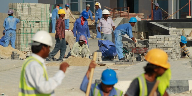 DOHA, QATAR - OCTOBER 24: Foreign workers lay an entrance road at the construction site of a new hotel in the new City Center and West Bay district on October 24, 2010 in Doha, Qatar. The International Monetary Fund (IMF) recently reiterated its projection for the Qatari economy with predictions of double digit growth for 2010 and 2011. Though natural gas and petroleum production are still the biggest two single sources of income, the non-energy sector overtook oil and gas in Qatari GDP for 2009. Qatar is heavily dependant on foreign labour from countries such as India, Sri Lanka, Bangladesh, the Phillipines and other Arab countries. Foreigners make up approximately two thirds of the Qatari population.  (Photo by Sean Gallup/Getty Images)