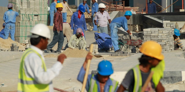 DOHA, QATAR - OCTOBER 24: Foreign workers lay an entrance road at the construction site of a new hotel in the new City Center and West Bay district on October 24, 2010 in Doha, Qatar. The International Monetary Fund (IMF) recently reiterated its projection for the Qatari economy with predictions of double digit growth for 2010 and 2011. Though natural gas and petroleum production are still the biggest two single sources of income, the non-energy sector overtook oil and gas in Qatari GDP for 2009. Qatar is heavily dependant on foreign labour from countries such as India, Sri Lanka, Bangladesh, the Phillipines and other Arab countries. Foreigners make up approximately two thirds of the Qatari population. (Photo by Sean Gallup/Getty Images)