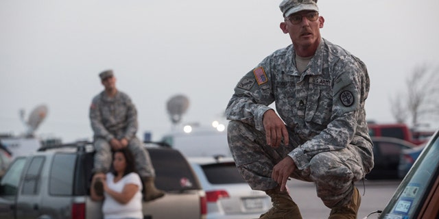 Staff Sgt. John Robertson waits in a parking lot outside of the Fort Hood military base for updates on April 2, 2014.