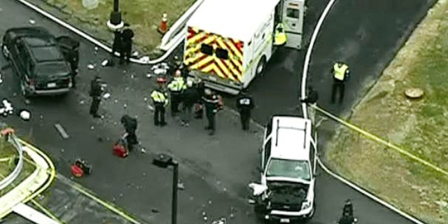 In this image made from video and released by WJLA-TV, authorities investigate the scene of a accident near a gate to Fort Meade, Md., on Monday, March 30, 2015. A spokesman at Fort Meade says two people are being treated for injuries at one of the gates of the sprawling Army installation near Baltimore. (AP Photo/WJLA-TV) MANDATORY CREDIT