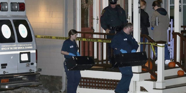 November 18, 2013: Workers from the Massachusetts medical examiner's office carry two small boxes to a home in a neighborhood of Arlington, Mass.