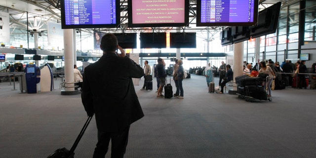 Passengers check flight information at Marseille-Provence Airport, in Marignane, southern France, Tuesday, June 11, 2013.