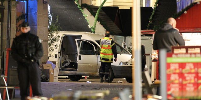 Dec. 22, 2014: A police officer guards the van that crashed into a French Christmas market in Nantes. French authorities urged calm after a series of attacks across the country left dozens of people injured, and said there was no evidence the attacks were connected by any terrorist motive. (AP Photo/Laetitia Notarianni)