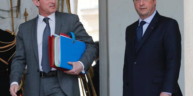 French Prime Minister Manuel Valls, left, and French president Francois Hollande leave at the end of the Cabinet meeting at the Elysee Palace in Paris Wednesday, April . 23, 2014. (AP Photo/Jacques Brinon)