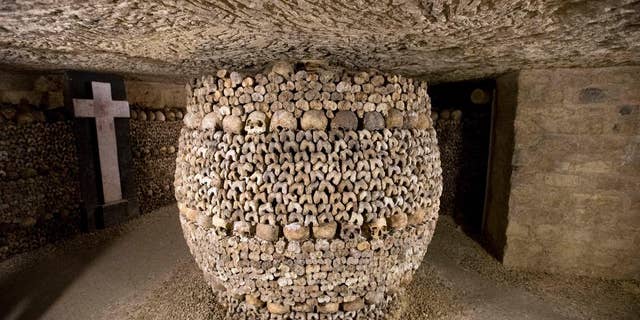 In this photo taken Tuesday, Oct. 14, 2014, skulls and bones are stacked at the Catacombs in Paris, France. The subterranean tunnels, stretching 2 kilometers (1.24 miles), cradle the bones of some 6 million Parisians from centuries past and once gave refuge to smugglers. The site used to close at 5 p.m., but is now staying open until 8 p.m. The change is mainly aimed at allowing more people to visit and reducing long lines, since it can only hold a limited number of people at a time and visits can’t be reserved in advance. (AP Photo/Francois Mori)