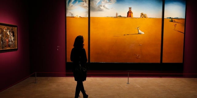 In this photo taken Monday Nov. 19, 2012, a women looks at a painting by Spanish artist Salvador Dali (1904-1989) during the presentation to the press of the exhibition "Dali" at the Centre Pompidou modern art museum, in Paris.