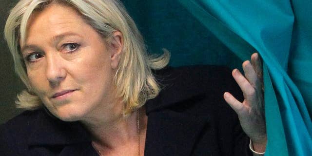 FILE - This Sunday, March 29, 2015 file photo shows French far-right leader and National Front Party, Marine Le Pen, exiting from a polling booth after voting for the second round of local elections in Henin-Beaumont, northern France. A top official in the French far-right National Front party says its leader, Marine Le Pen, will stand trial over comments she made in 2010 comparing Muslim street prayers to an occupation of French territory. Wallerand de Saint Just, Le Pen's former lawyer and a ranking member of the party, confirmed the judicial decision on Tuesday to send Le Pen to trial on charges of inciting racial hatred. (AP Photo/Michel Spingler, File)