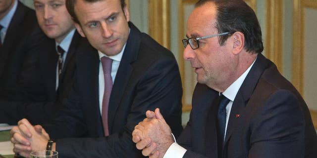 France's President Francois Hollande, right, and Economy Minister Emmanuel Macron, meet oil industry group leaders, on gasoline prices, at the Elysee Palace in Paris, Monday, Dec. 8, 2014. (AP Photo/Michel Euler, Pool)