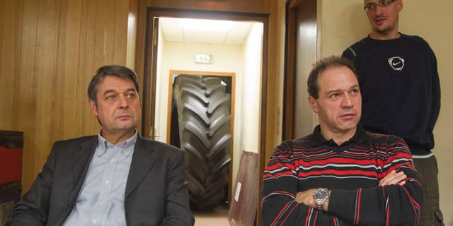 Jan. 6, 2014: A worker at the Goodyear tire factory guards the human resources chief, Bernard Glesser, left, and the firm's production manager Michel Dheilly, right, who were blocked from leaving the plant in Amiens, northern France.
