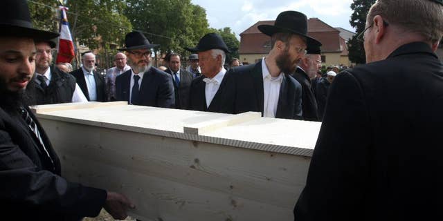 Members of the Jewish community of Strasbourg carry a coffin bearing the remains of a Jewish victim of Nazi anatomist August Hirt, during a ceremony at the Jewish cemetery of Cronenbourg, eastern France, Sunday, Sept. 6, 2015. The remains of Holocaust victims kept for decades in a French medical school were laid to rest on Sunday. (AP Photo/Christian Lutz)