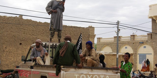 FILE - In this Aug. 31, 2012 file photo, fighters from Islamist group Ansar Dine stand guard in Timbuktu, Mali, as they prepare to publicly lash a member of the Islamic Police found guilty of adultery. France is moving surveillance drones to western Africa amid rising concerns that an al-Qaida offshoot and its allies who control northeast Mali represent a major threat to French interests abroad _ and possibly at home. With six French hostages held by Islamic militants in the region, France is facing a delicate task, but has garnered support from other Western powers including the United States to keep Mali from becoming a new launchpad for global terrorism. (AP Photo, File)