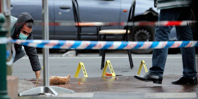 Jan. 8, 2015: Police officers look for evidence after a shooting in Montrouge, outside Paris. A police union official said that a female officer died of wounds sustained when she was shot while investigating a traffic accident. (AP Photo/Christophe Ena)