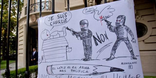 A cartoon style drawing hangs outside France's embassy that reads in Spanish "The pencil is the most peaceful weapon, don't mess with humor" in solidarity with those killed in an attack at the Paris offices of the weekly newspaper Charlie Hebdo in Buenos Aires, Argentina, Wednesday, Jan. 7, 2015. Masked gunmen stormed the offices of the satirical newspaper that caricatured the Prophet Muhammad, methodically killing 12 people Wednesday, including the editor, before escaping in a car. It was France's deadliest postwar terrorist attack. (AP Photo/Natacha Pisarenko)