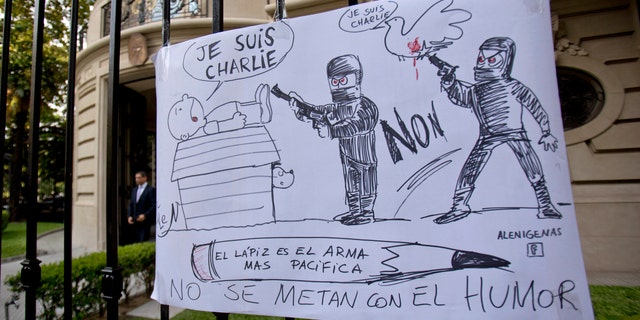 A cartoon style drawing hangs outside France's embassy that reads in Spanish "The pencil is the most peaceful weapon, don't mess with humor" in solidarity with those killed in an attack at the Paris offices of the weekly newspaper Charlie Hebdo in Buenos Aires, Argentina, Wednesday, Jan. 7, 2015. Masked gunmen stormed the offices of the satirical newspaper that caricatured the Prophet Muhammad, methodically killing 12 people Wednesday, including the editor, before escaping in a car. It was France's deadliest postwar terrorist attack. (AP Photo/Natacha Pisarenko)