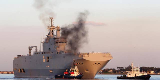 FILE - In this March 5, 2014 file photo, French-built warship BPC Vladivostock, designed to strengthen Russia's ability to deploy troops, tanks and helicopter gunships, leaves the Saint Nazaire's harbor, western France, for its test run on the open sea off coast of France. French President Francois Hollande is defending plans to deliver a 1.1 billion-euro French-made warship to Russia, despite increasing pressure for tougher European sanctions against Moscow over the fighting in Ukraine. European Union foreign ministers are meeting Tuesday July 22, 2014 in Brussels, with some calling for an arms embargo or other new punishment against Russia. (AP Photo/David Vincent, File)