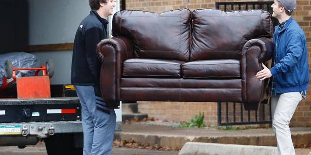 File-This March 10, 2015, file photo shows two men loading a couch from the now closed University of Oklahoma's Sigma Alpha Epsilon fraternity house into a moving truck, in Norman, Okla. Fraternities dominate social life at many American universities, but lately these organizations of male college students have been receiving unwanted attention for their bad behavior. At the University of Oklahoma, one prominent fraternity was shut down after members were caught on video performing a racist chant. (AP Photo/Sue Ogrocki, File)