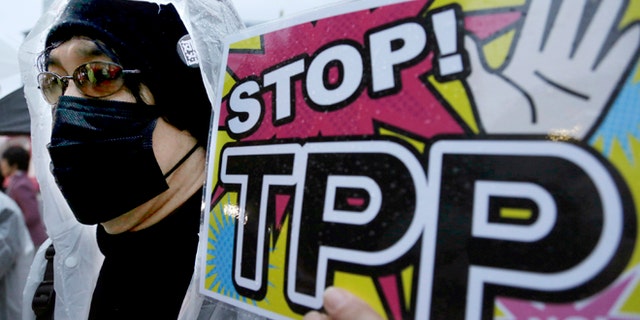 FILE - In this April 22, 2104 file photo, a protester holds a placard during a rally against the Trans-Pacific Partnership (TPP) in Tokyo. Just over two decades after lobbying unsuccessfully against the North American Free Trade Agreement, U.S. labor unions are again voicing strong reservations to a proposed major trade-liberalization deal. (AP Photo/Shizuo Kambayashi, File)
