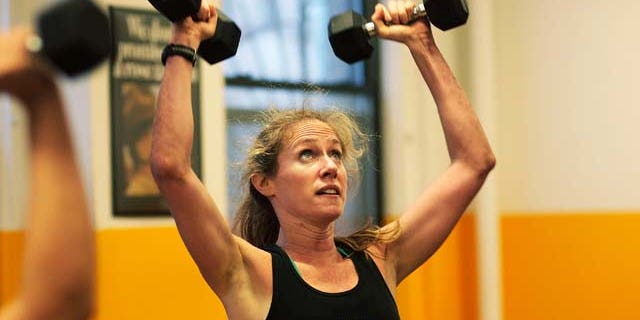 MARCH 17: A woman lifts dumbells during a workout at Warrior Fitness Boot Camp gym March 17, 2009 in the Midtown neighborhood of New York City. (Photo by Chris Hondros/Getty Images)